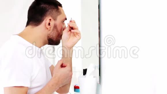 一个拿着镊子的男人在浴室里拧眉视频的预览图