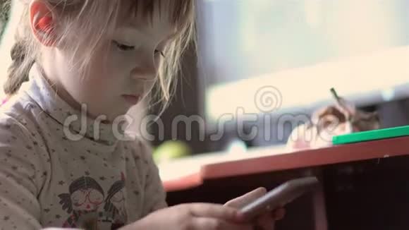 小女孩玩你的手机和触摸屏玩得开心视频的预览图