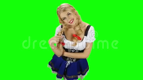 穿着巴伐利亚服装的女孩玩弄她的头发笑绿色屏幕视频的预览图