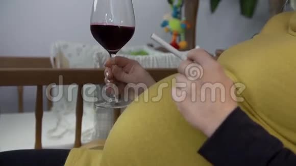 孕妇端着一杯酒和一支烟视频的预览图