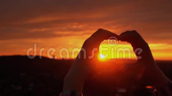 剪影手在心形与日落里面视频的预览图