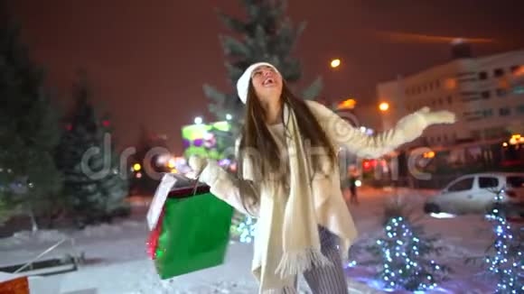 概念圣诞购物美丽的女人手里拿着多种颜色的包裹晚上散步圣诞节视频的预览图