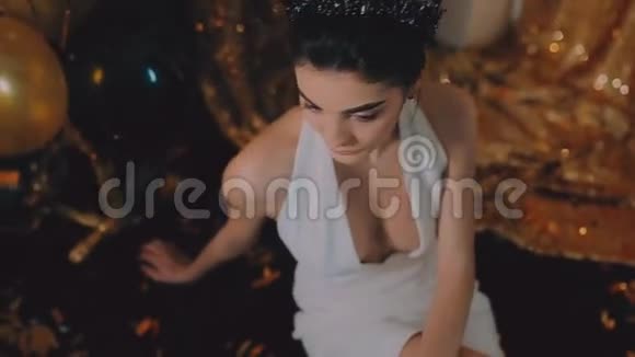 穿白色连衣裙戴皇冠的年轻女孩黄金背景气球视频的预览图