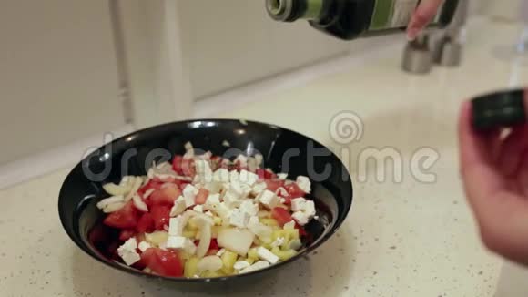 桌子上有一盘切菜在盘子里慢慢地倒入橄榄油视频的预览图