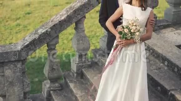 幸福的新婚夫妇站在老城堡的楼梯上4K视频的预览图
