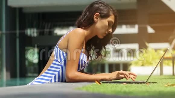 女模特在游泳池自由职业笔记本电脑视频的预览图