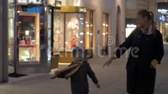 在维也纳奥地利晚上在广场上散步一位年轻的母亲牵着一个小儿子的手视频的预览图
