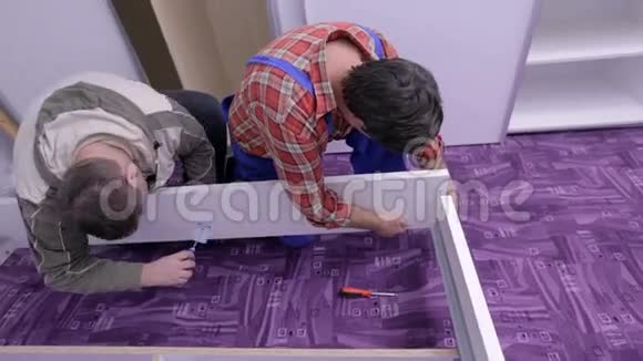 两个人用螺丝刀处理床架视频的预览图