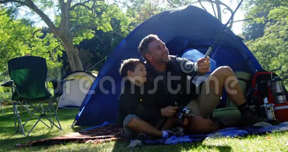 父子俩在帐篷外拿着鱼竿视频的预览图