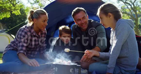 家庭在帐篷外烤棉花糖视频的预览图