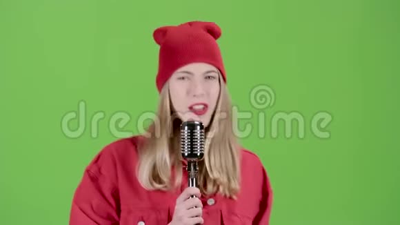 穿时髦衣服的女孩用复古麦克风唱歌绿色屏幕视频的预览图