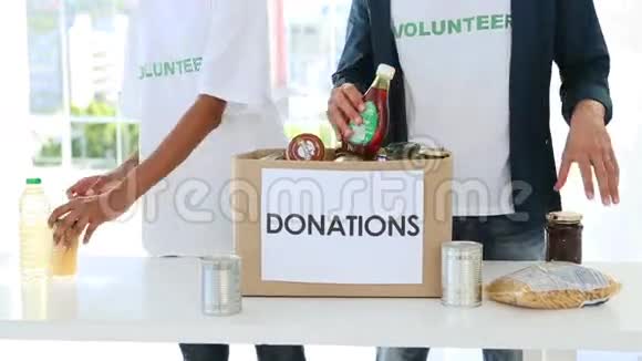 年轻的志愿者团队打包食物捐赠箱视频的预览图
