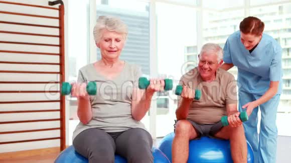 两名老年公民与理疗师一起锻炼视频的预览图