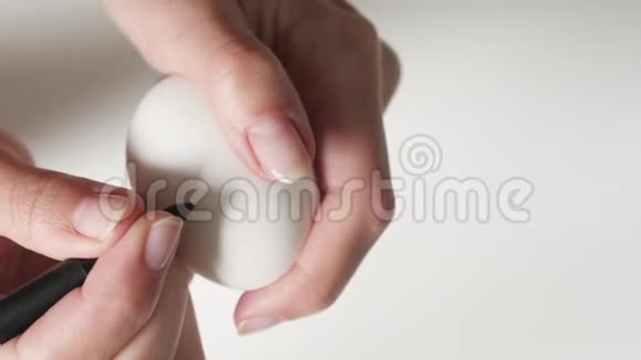 一个面目全非的女人拿着一个标记在复活节的一个破碎的鸡蛋上用黑色黑色的心关于这个概念视频的预览图