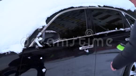 男人用雪刷清洁汽车视频的预览图