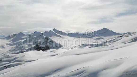 鸟瞰冬山景观埃尔布鲁斯南部度假胜地积雪覆盖的岩石斜坡视频的预览图
