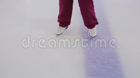 在白色溜冰鞋孩子们的腿的侧面在冰上骑马视频的预览图