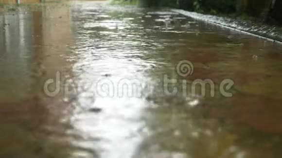 倾盆大雨落在人行道上的水坑里特写镜头慢动作4k视频的预览图