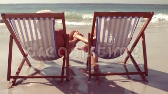 平静的老夫妇手牵着沙滩椅视频的预览图