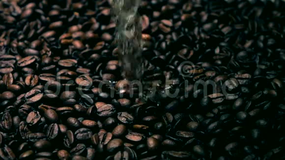 在烤咖啡豆上倒水的超慢动作镜头冷色调视频的预览图