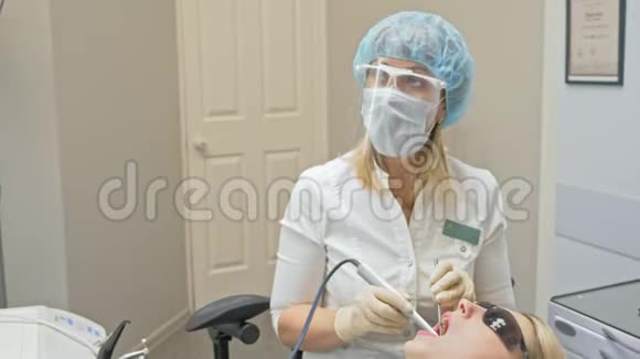 医生用特殊的口腔检查数字微相机检查牙齿医生和助理保护工作视频的预览图