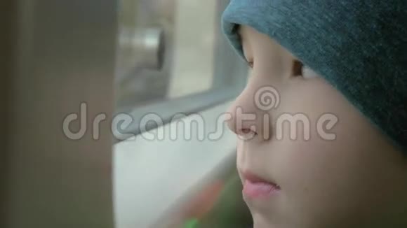 在火车上一个戴着帽子的小男孩向窗外看视频的预览图