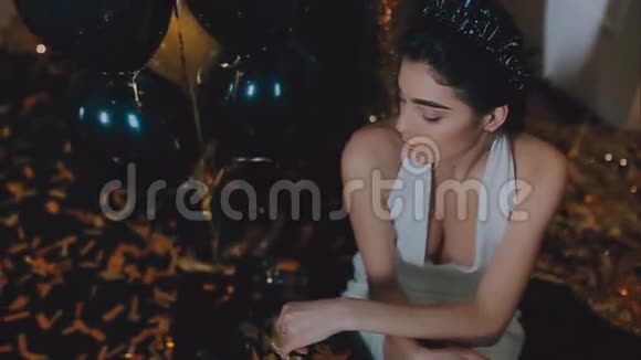 穿白色连衣裙戴皇冠的年轻女孩黄金背景气球视频的预览图