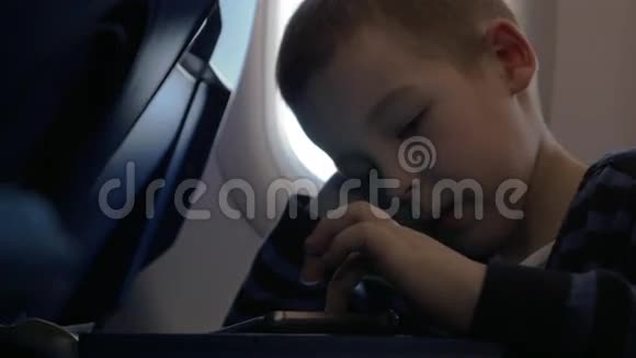 飞机上坐着一个小男孩在手机上玩游戏视频的预览图