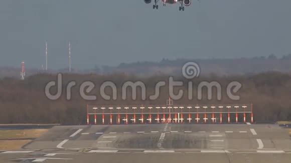 晴天银色客机缓缓降落在机场的跑道上视频的预览图