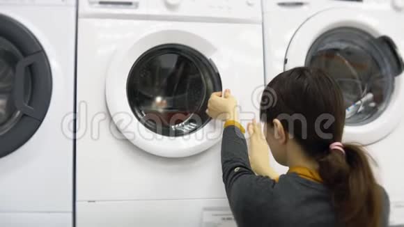 一位年轻女子在家电店里挑选洗衣机视频的预览图