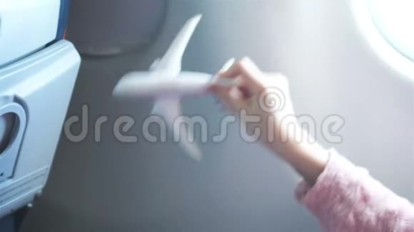 特写手举着飞机模型玩具背景窗在飞机内部视频的预览图