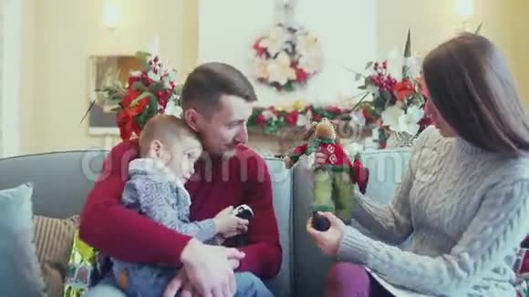 在圣诞节的内部幸福的家庭妈妈在玩宝贝视频的预览图