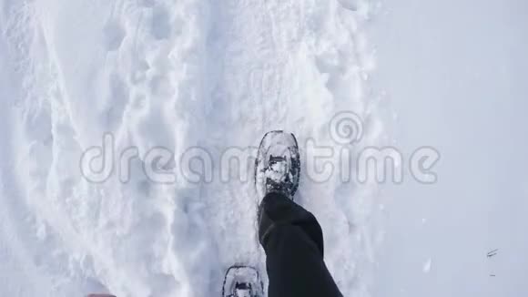 头顶的POV男子徒步旅行和步行与雪鞋户外白色雪道在山野野地在冬季细节视频的预览图