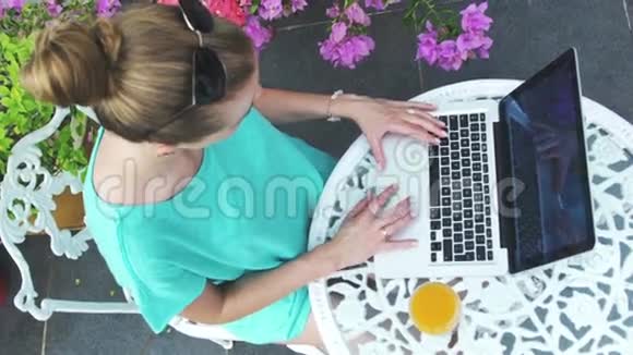 一个年轻女人在笔记本电脑前的肖像有笔记本电脑的女人在度假户外视频的预览图