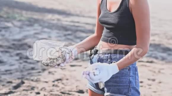 一群志愿者清理海滩把垃圾放进袋子里视频的预览图
