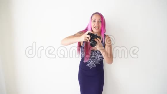 粉色头发的女孩在老式相机上拍照视频的预览图
