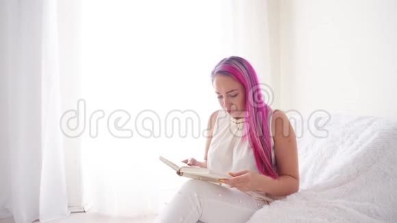 粉红头发的女孩在看书感受情感视频的预览图