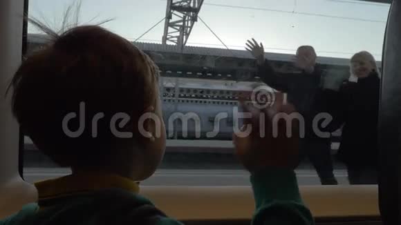 火车上的小孩在他离开时向爷爷奶奶挥手视频的预览图