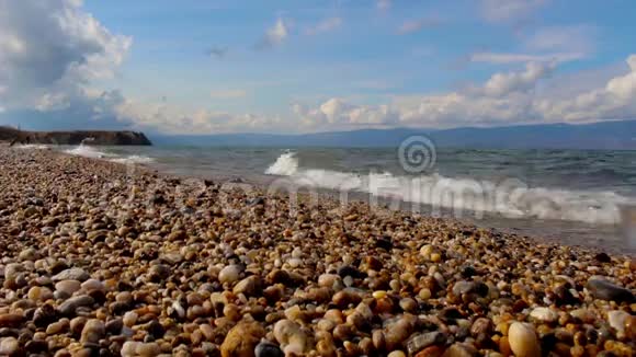 秋天贝加尔湖的卵石滩景观海边浪花飞溅视频的预览图