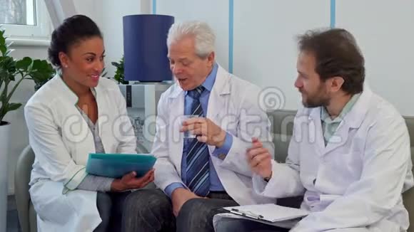 由三名医生组成的医疗队坐在医院的沙发上视频的预览图