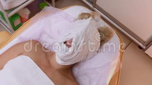 在美容师做手术的女人脸上戴着毛巾视频的预览图
