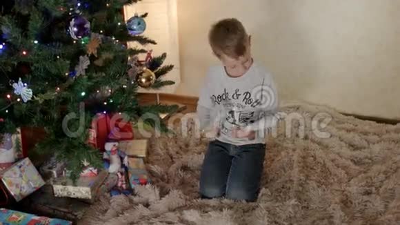 新年树下的男孩把给圣诞老人的信放在信封里视频的预览图