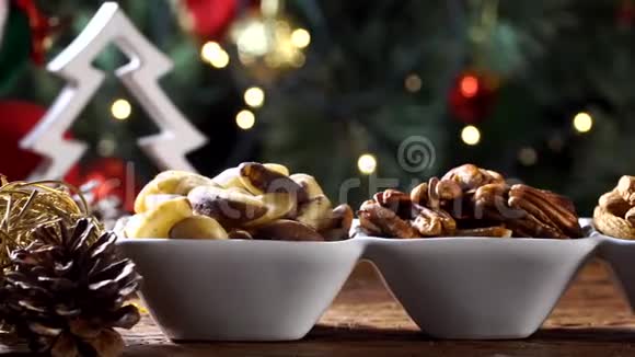 核桃仁巴西坚果和杏仁在一个碗里的乡村老木桌与圣诞节背景一张幻灯片视频的预览图