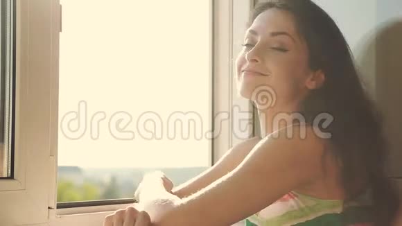 坐在阳台上微笑的美丽女人视频的预览图
