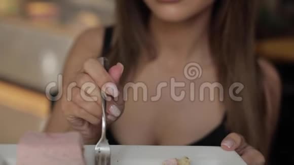 漂亮性感的年轻女人用叉子吃开胃的糕点蛋糕视频的预览图