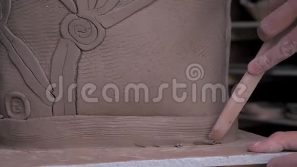 一位漂亮的女陶工从她的产品中取出多余的粘土视频的预览图
