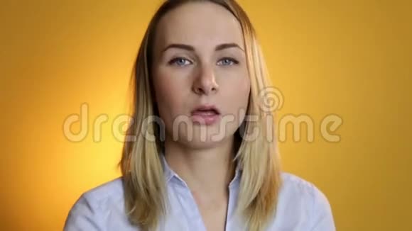 年轻女子在黄色背景下打喷嚏视频的预览图