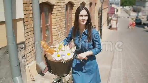 女孩骑着自行车走在街上花篮里放着鲜花太阳在夏天照耀着慢的斯泰迪卡姆的镜头视频的预览图