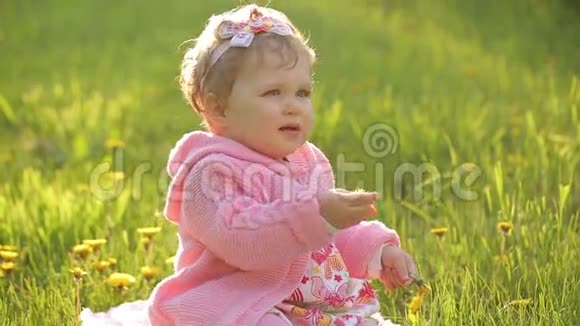 婴儿坐在绿草上视频的预览图