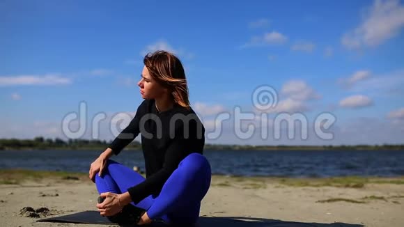 年轻女性在日落时在夏日沙滩上做瑜伽运动锻炼身体视频的预览图